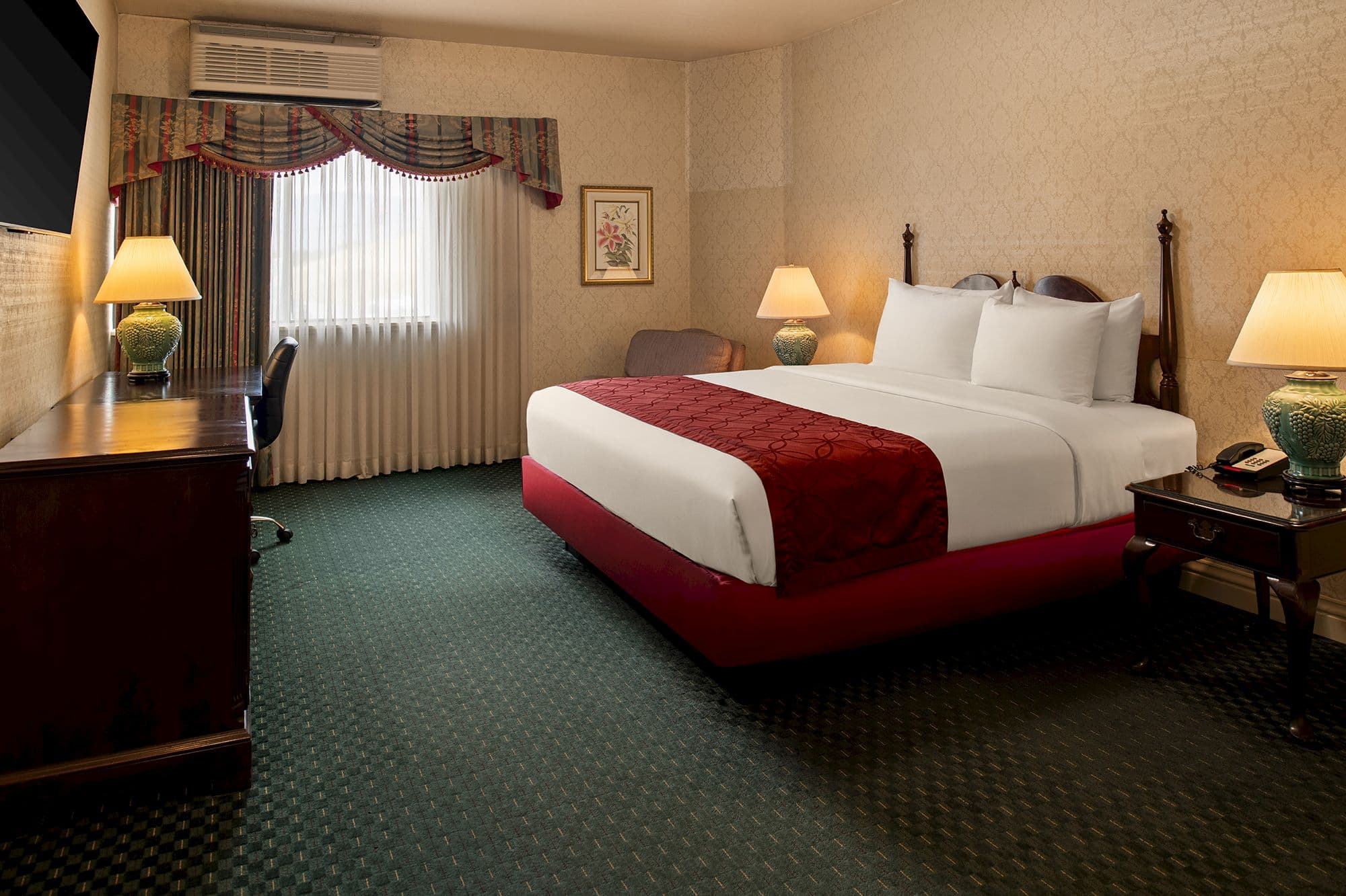 King guest room with a cherry wood four-poster bed, burgundy runner, green ceramic lamps and a writing desk