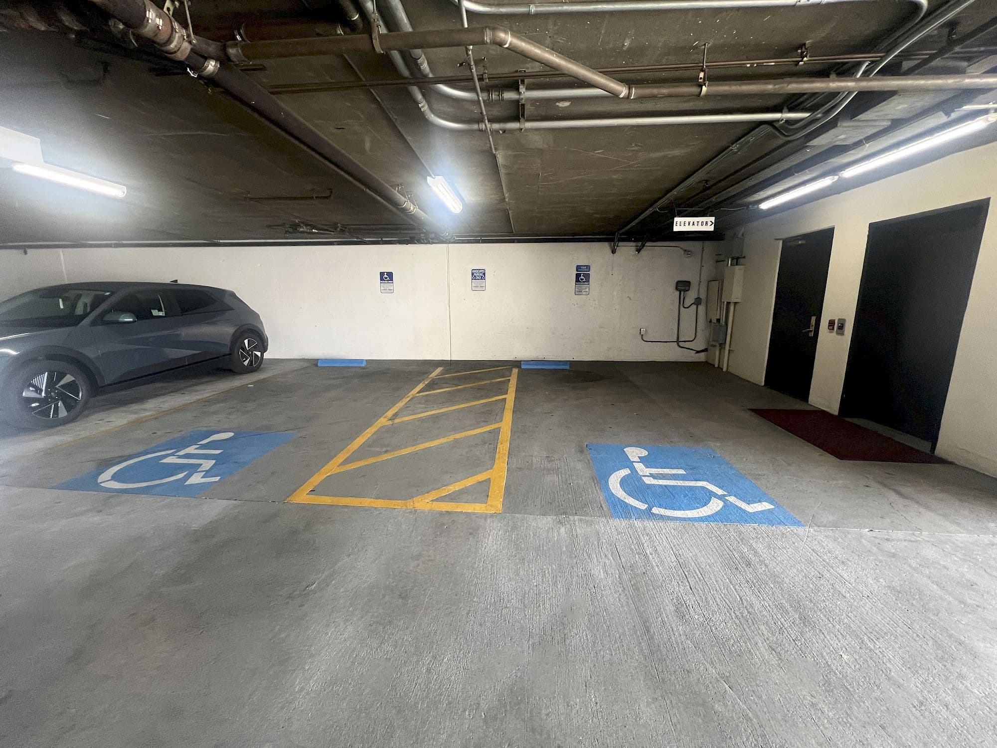 Accessible parking spaces with a van-accessible aisle next to the garage elevator